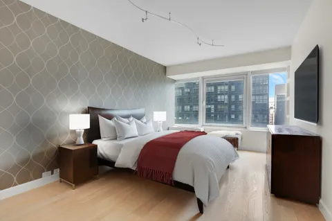 a bed sitting in a bedroom next to a window