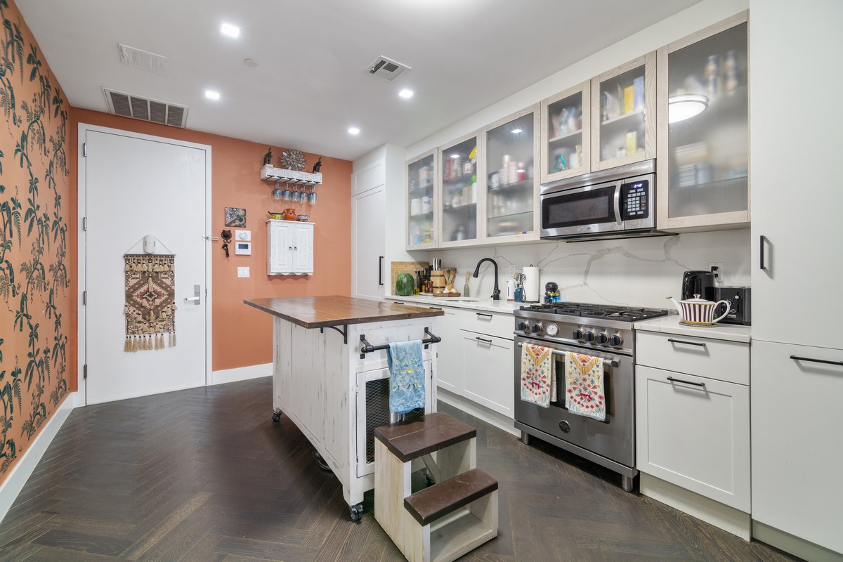 11-12 44th Drive, Unit 2B Queens, NY 11101 - Photo 8 of 15 a kitchen with stainless steel appliances granite countertop a stove and a sink