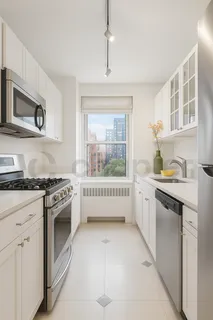 a kitchen with stainless steel appliances granite countertop white cabinets and window