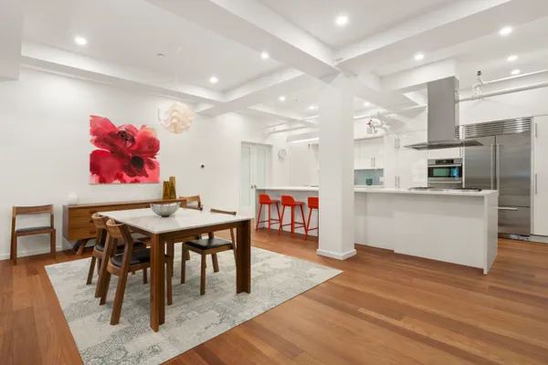 a open kitchen with stainless steel appliances kitchen island granite countertop a table chairs and a refrigerator