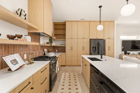 a kitchen that has a sink a stove and a wooden floor