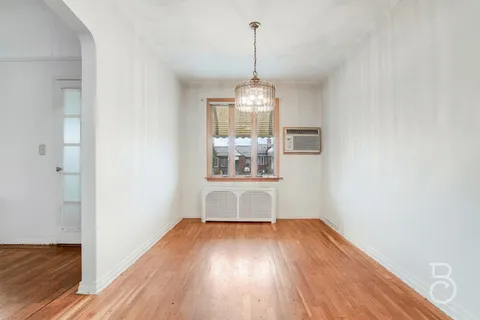 a room with wooden floor a ceiling fan and window