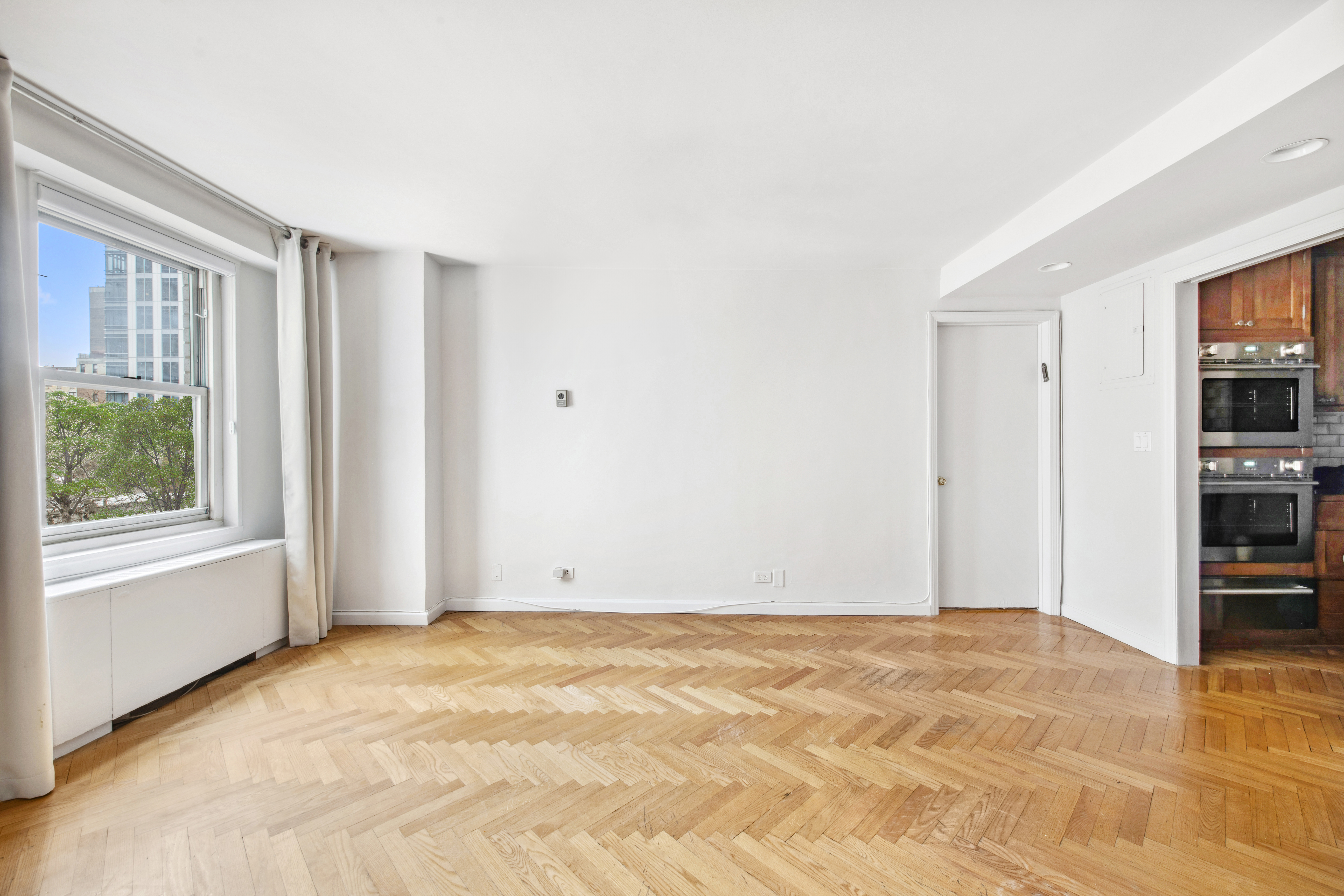 155 West 68th Street, Unit 404 Manhattan, NY 10023 - Photo 5 of 21 a view of an empty room with a window and closet area
