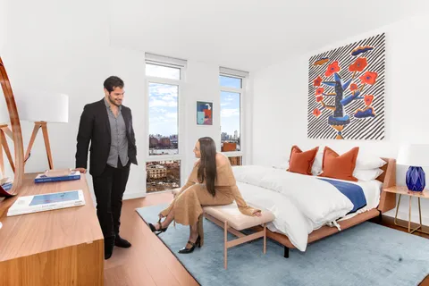 a bed room with a bed and a painting on the wall