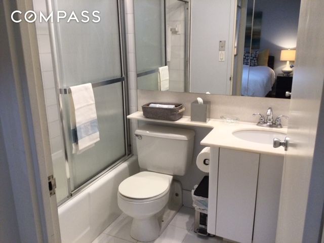 150 West 51st Street, Unit 1909 Manhattan, NY 10019 - Photo 7 of 12 a bathroom with a toilet sink and mirror