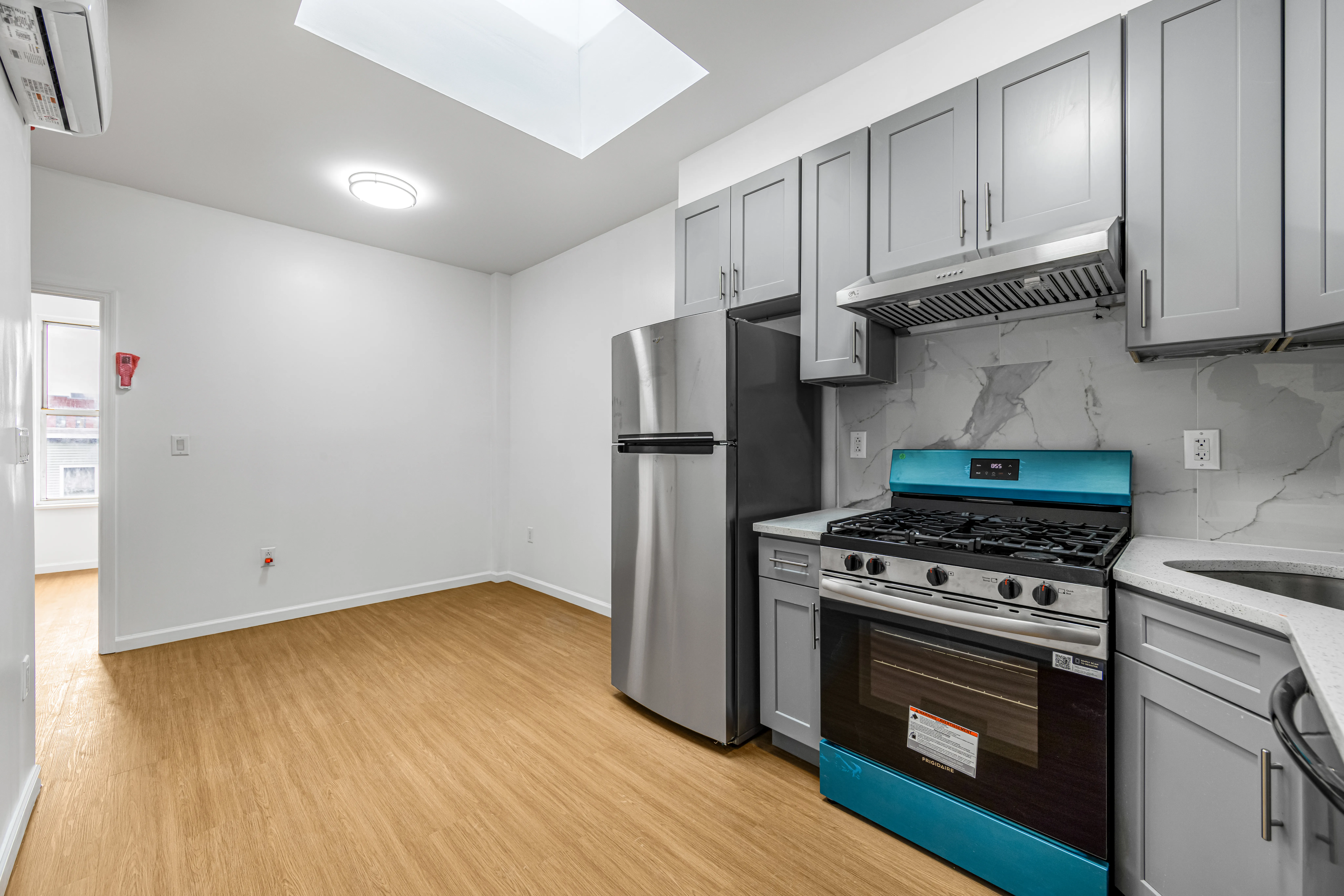 141 23rd Street, Unit 3L Brooklyn, NY 11232 - Photo 3 of 9 a kitchen with granite countertop wooden floors and stainless steel appliances