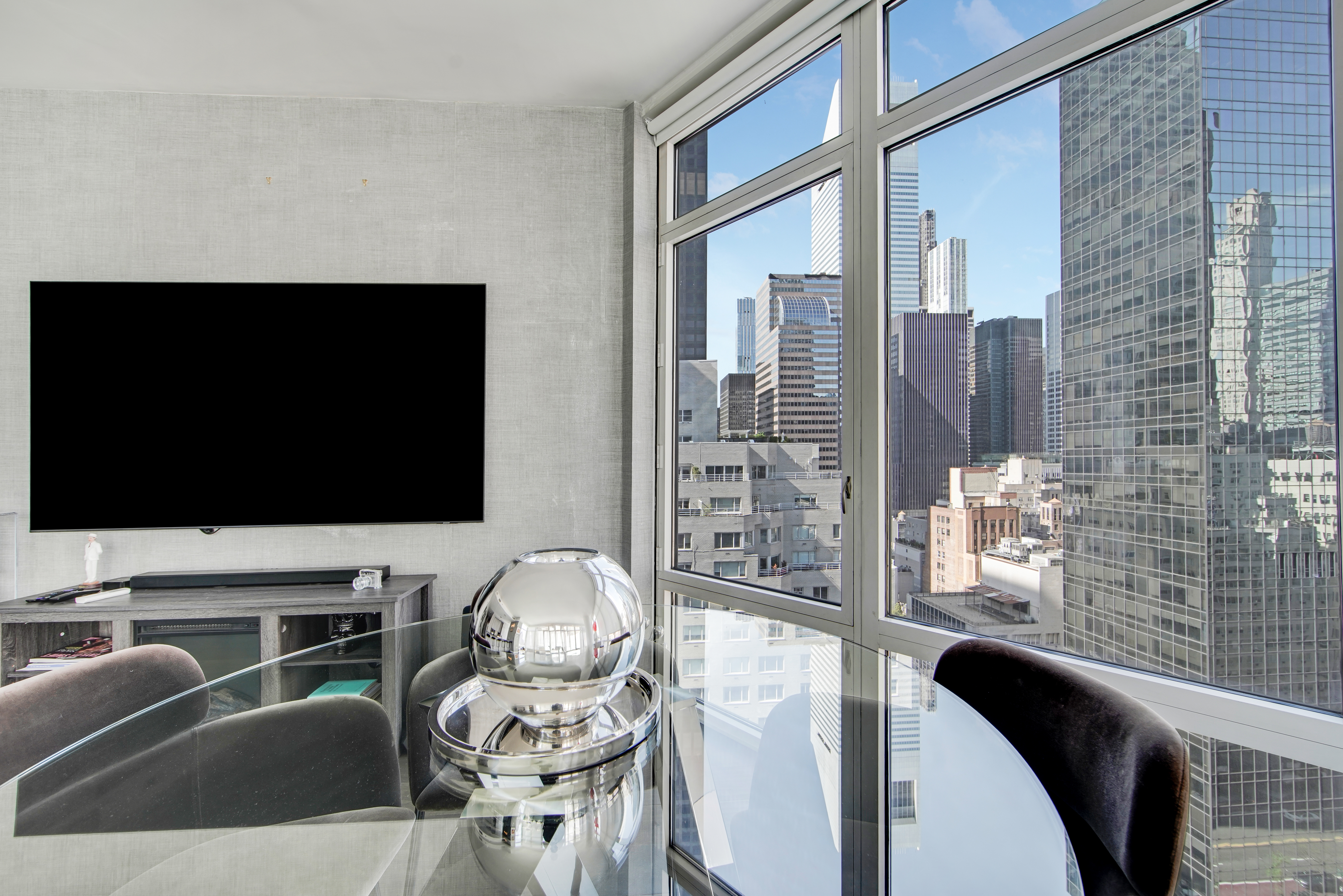 207 East 57th Street, Unit 20A Manhattan, NY 10022 - Photo 3 of 18 a living room with furniture and a flat screen tv