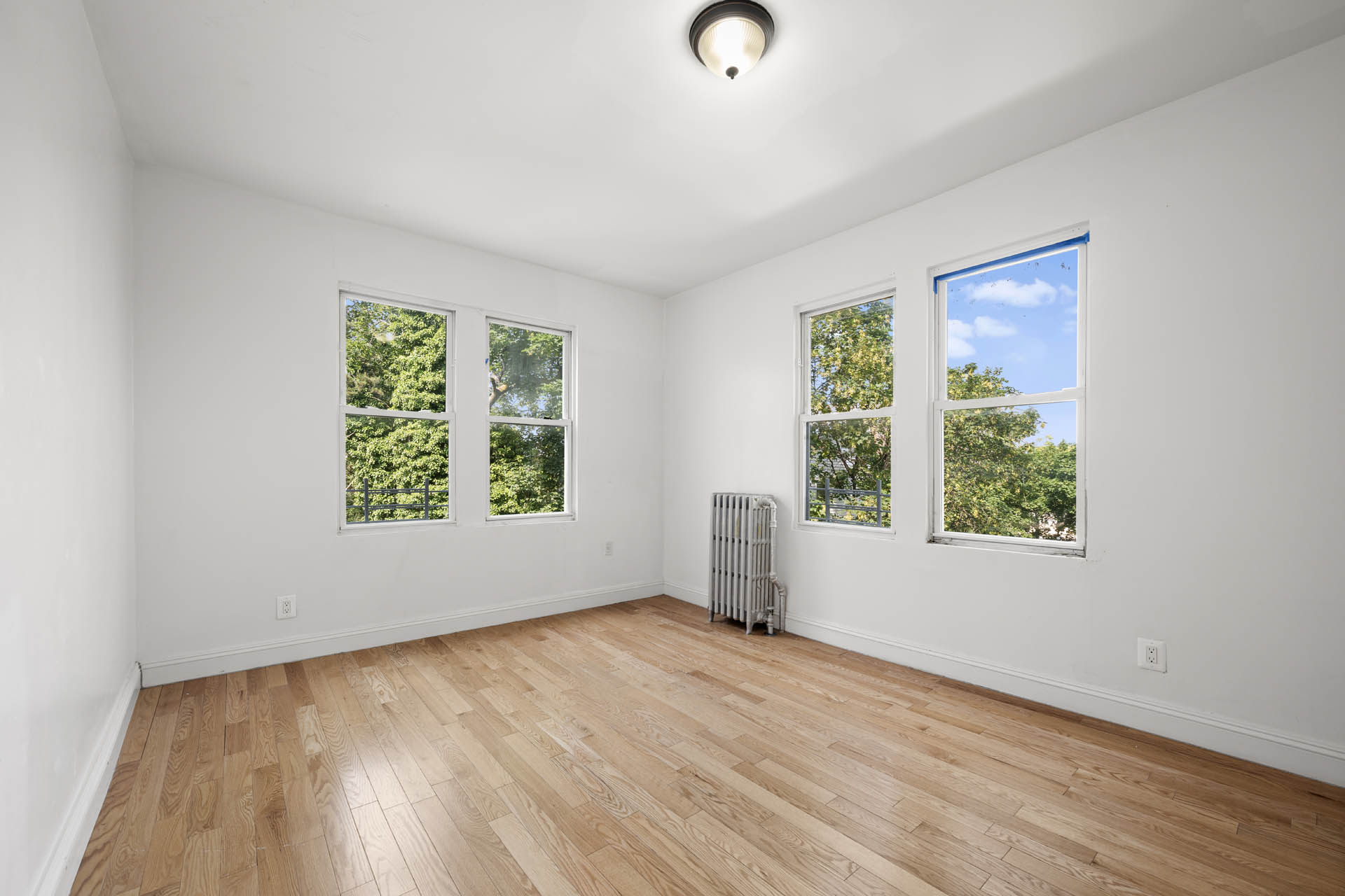 156 Summit Place, Unit 2 Bronx, NY 10463 - Photo 5 of 10 an empty room with wooden floor and windows