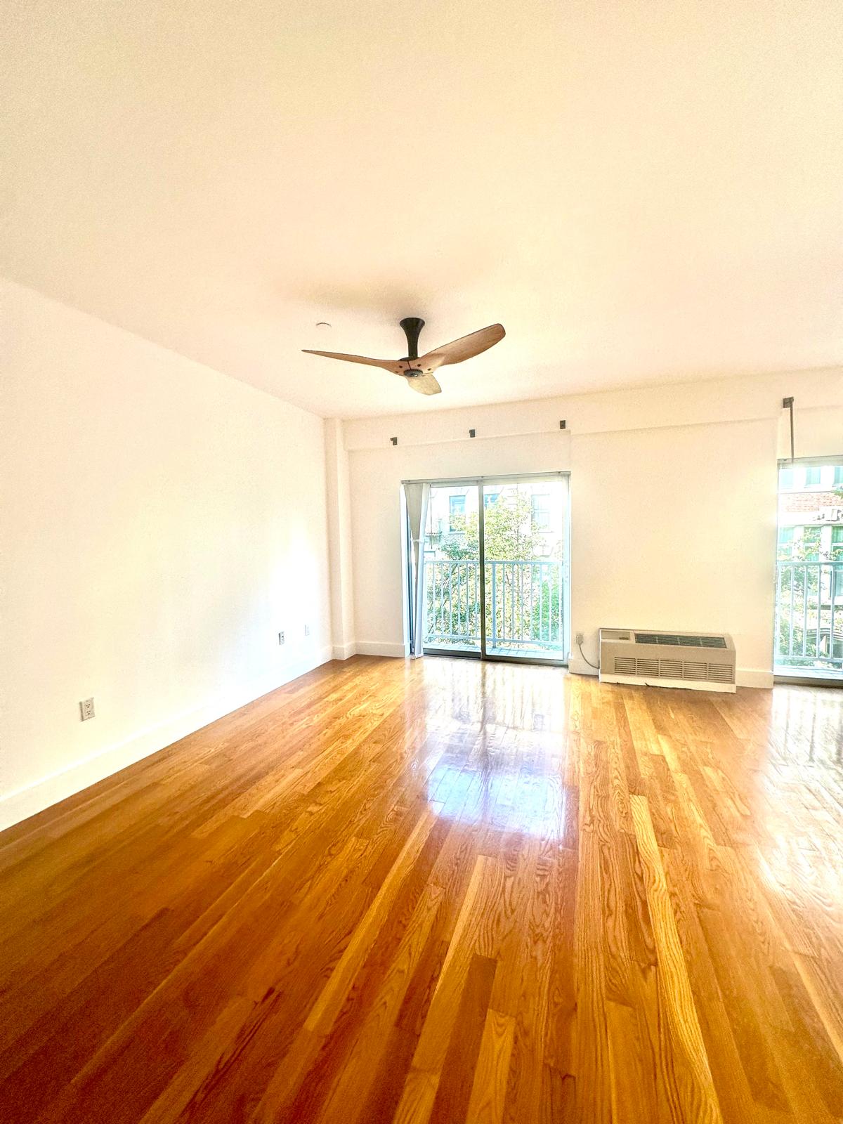 221 West 148th Street, Unit 4A Manhattan, NY 10039 - Photo 2 of 11 a view of an empty room with wooden floor and a window