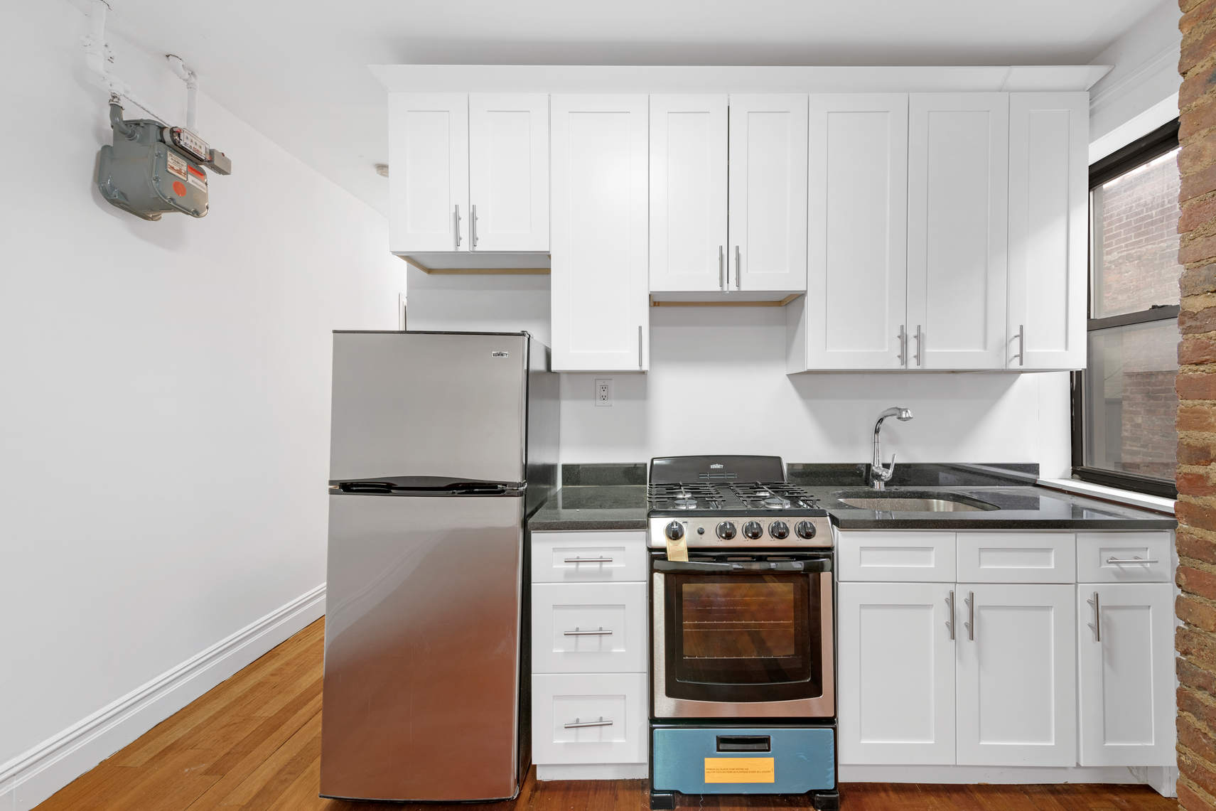214 East 82nd Street, Unit 34 Manhattan, NY 10028 - Photo 2 of 5 a kitchen with stainless steel appliances granite countertop a stove a sink and a refrigerator