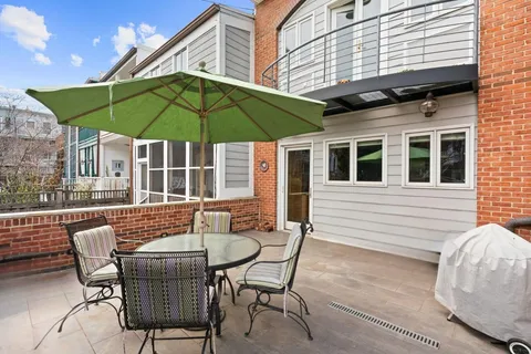 a patio with a table and chairs under an umbrella