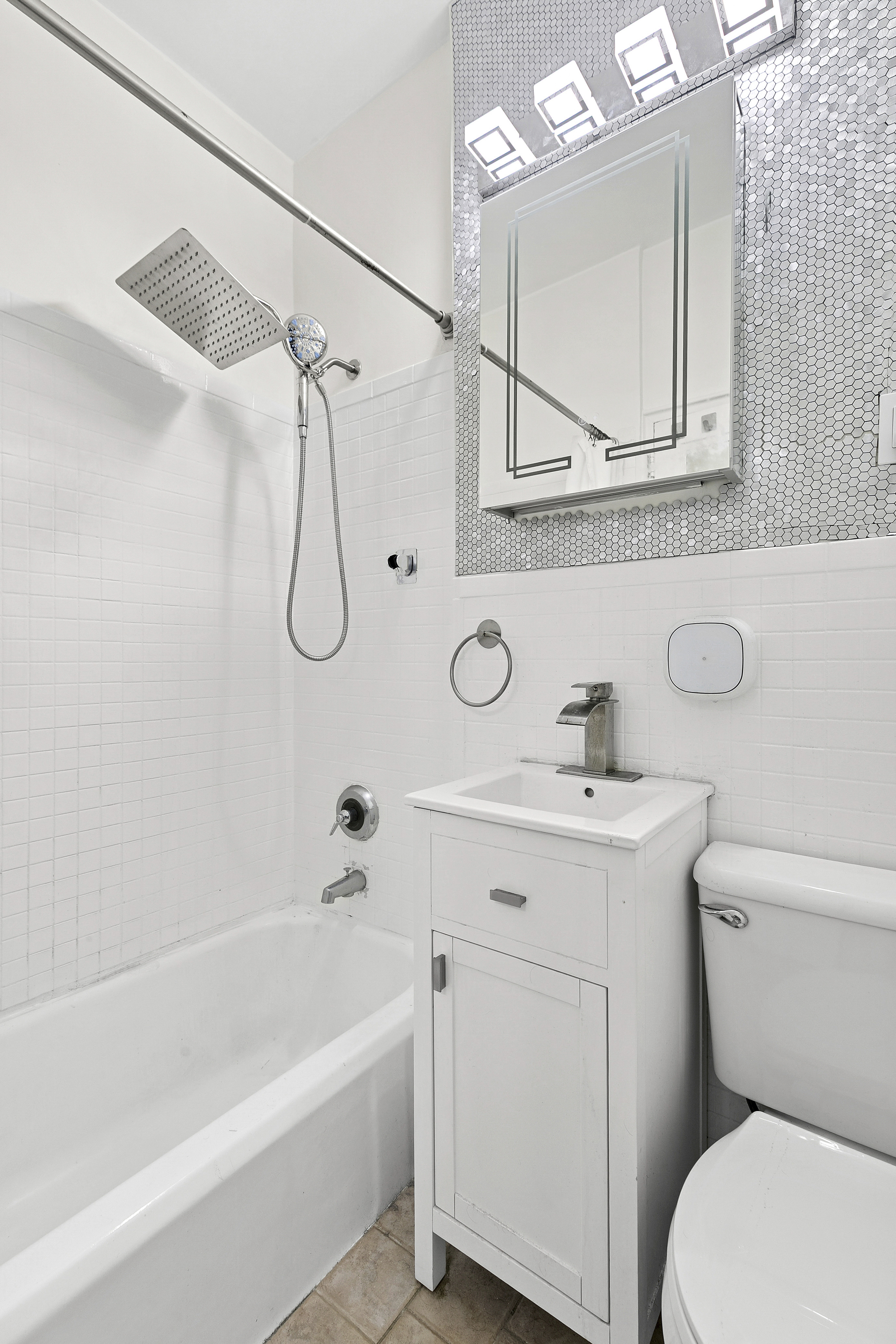 228 West 17th Street, Unit 4B Manhattan, NY 10011 - Photo 4 of 5 a bathroom with a sink a mirror a toilet and a bathtub