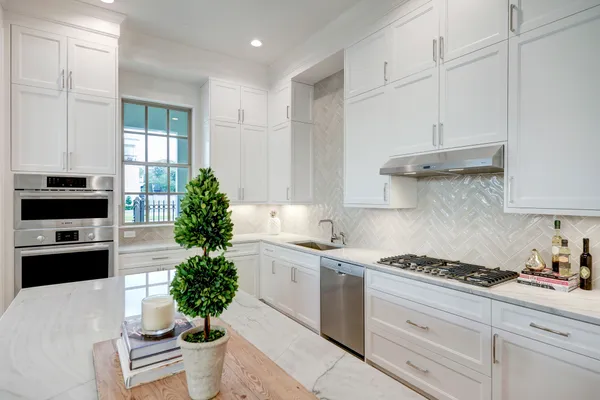 a kitchen with granite countertop a white cabinets and a stove