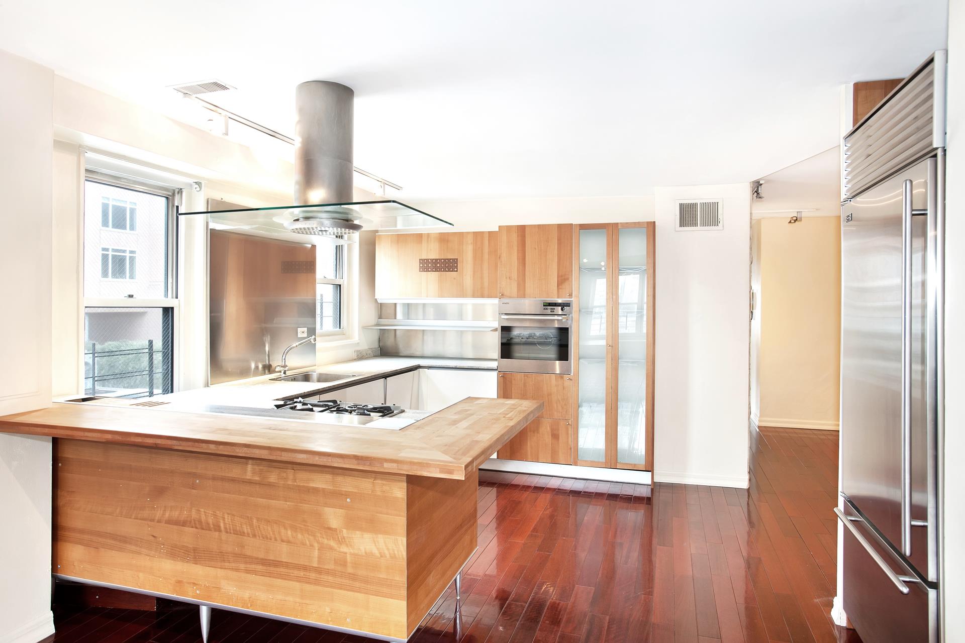220 East 60th Street, Unit 7CD Manhattan, NY 10022 - Photo 8 of 11 a room with kitchen island a sink stove and refrigerator