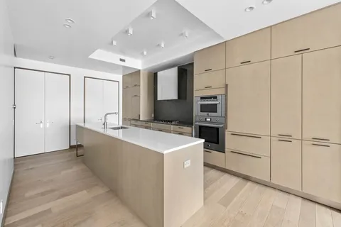 a large white kitchen with cabinets and stainless steel appliances