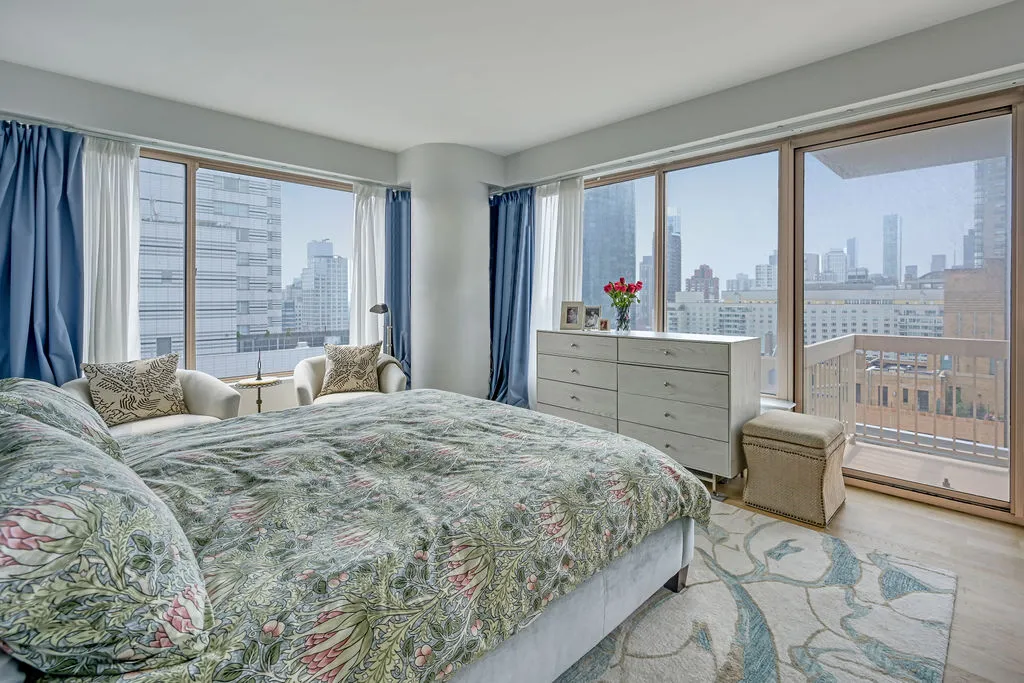 a bedroom with a bed and large windows