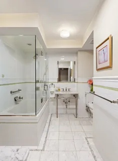 a spacious bathroom with a tub sink and mirror