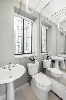 a bathroom with a double vanity sink toilet and mirror