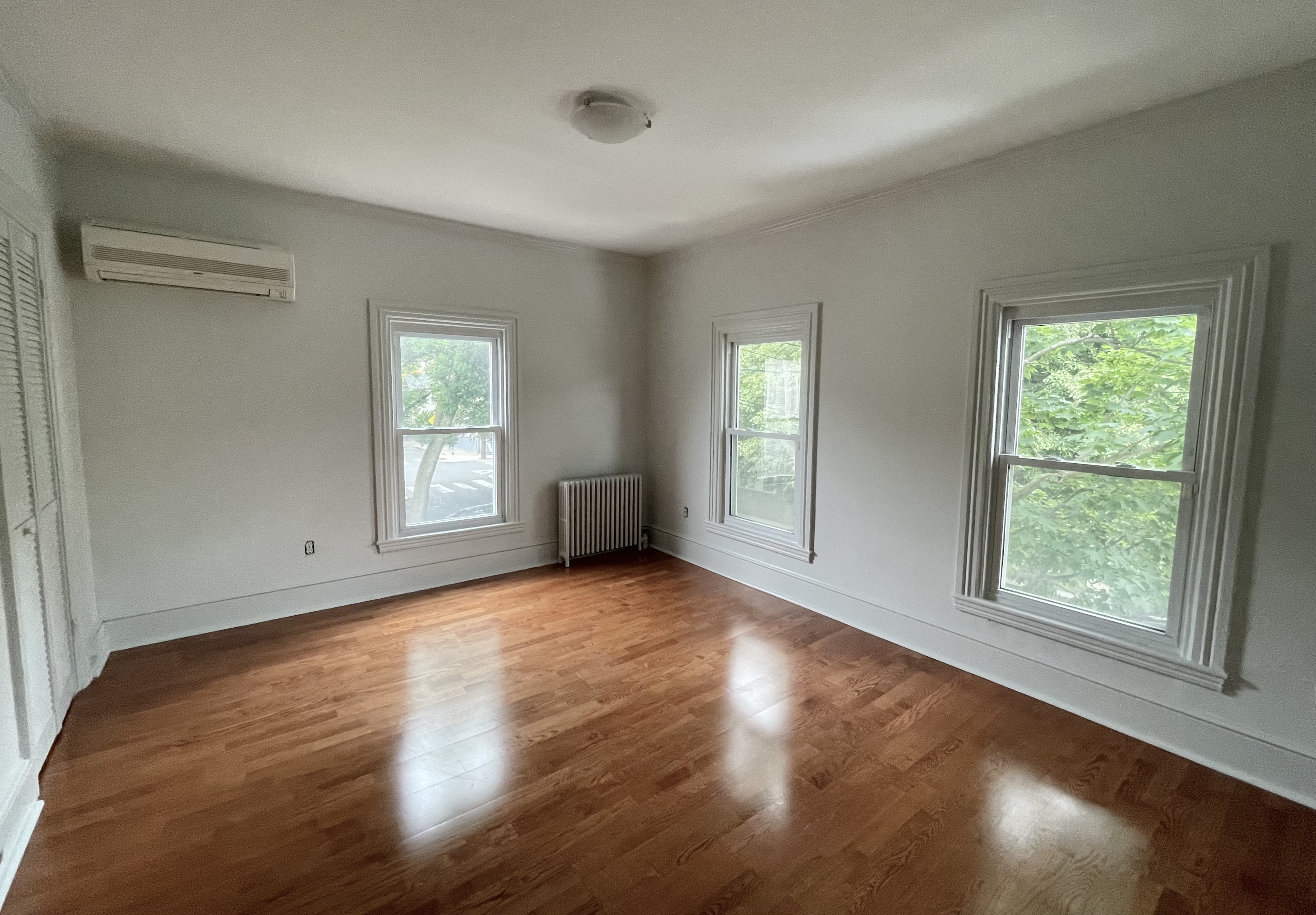 49 8th Street Cambridge, MA 02141 - Photo 5 of 6 an empty room with wooden floor and windows