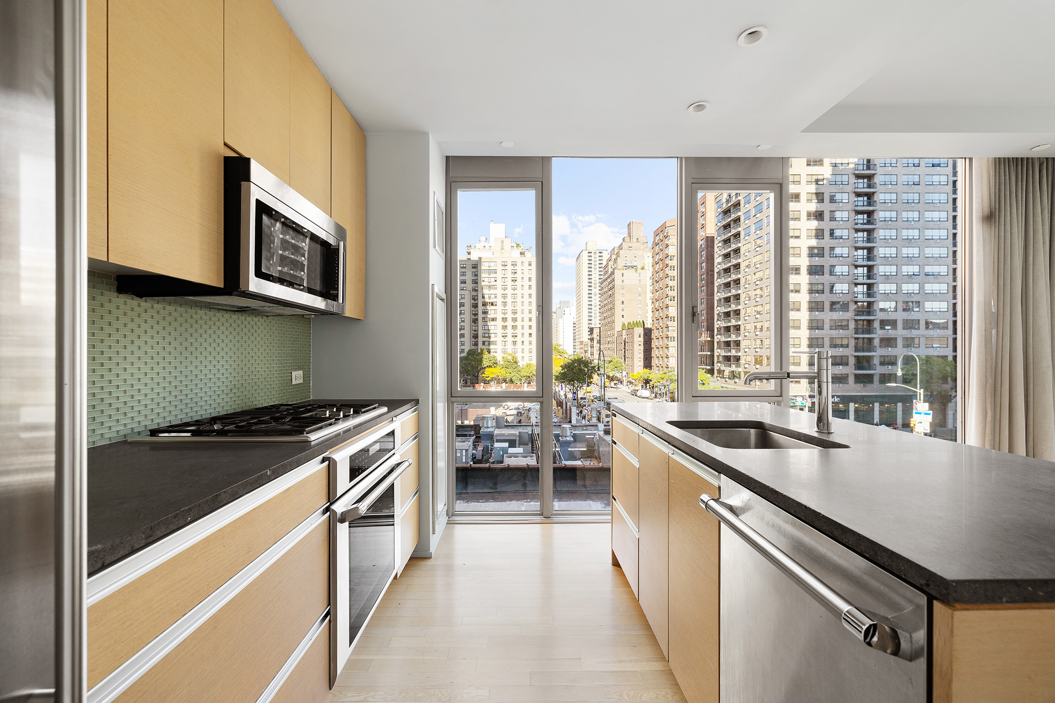 110 3rd Avenue, Unit 4C Manhattan, NY 10003 - Photo 5 of 17 a kitchen with stainless steel appliances granite countertop a sink stove and microwave