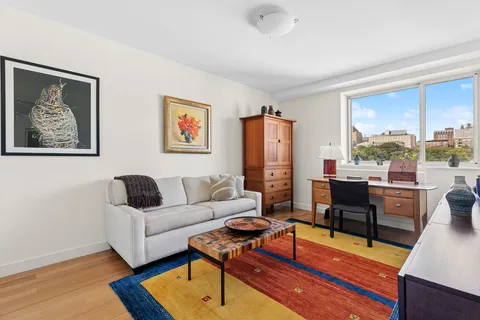 a living room with furniture a rug and a lamp