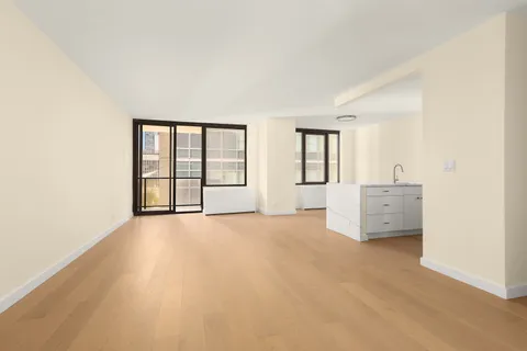 an empty room with windows and cabinet