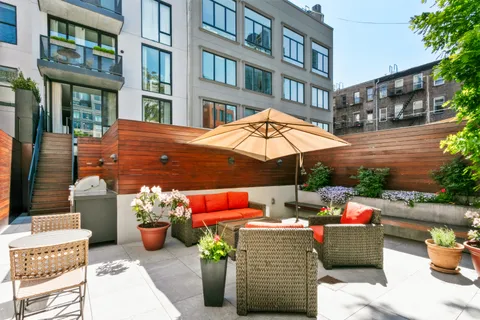 a view of a patio with a table and chairs under an umbrella