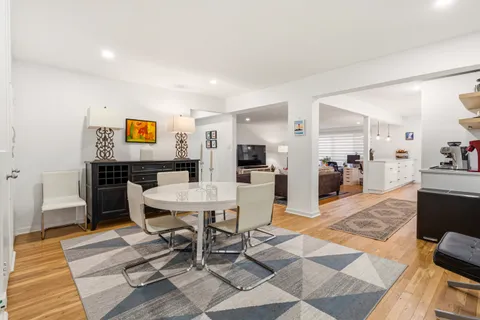 a living room with patio furniture and a dining table