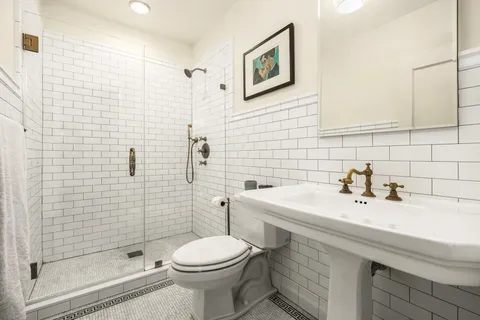 a bathroom with a sink a toilet and shower