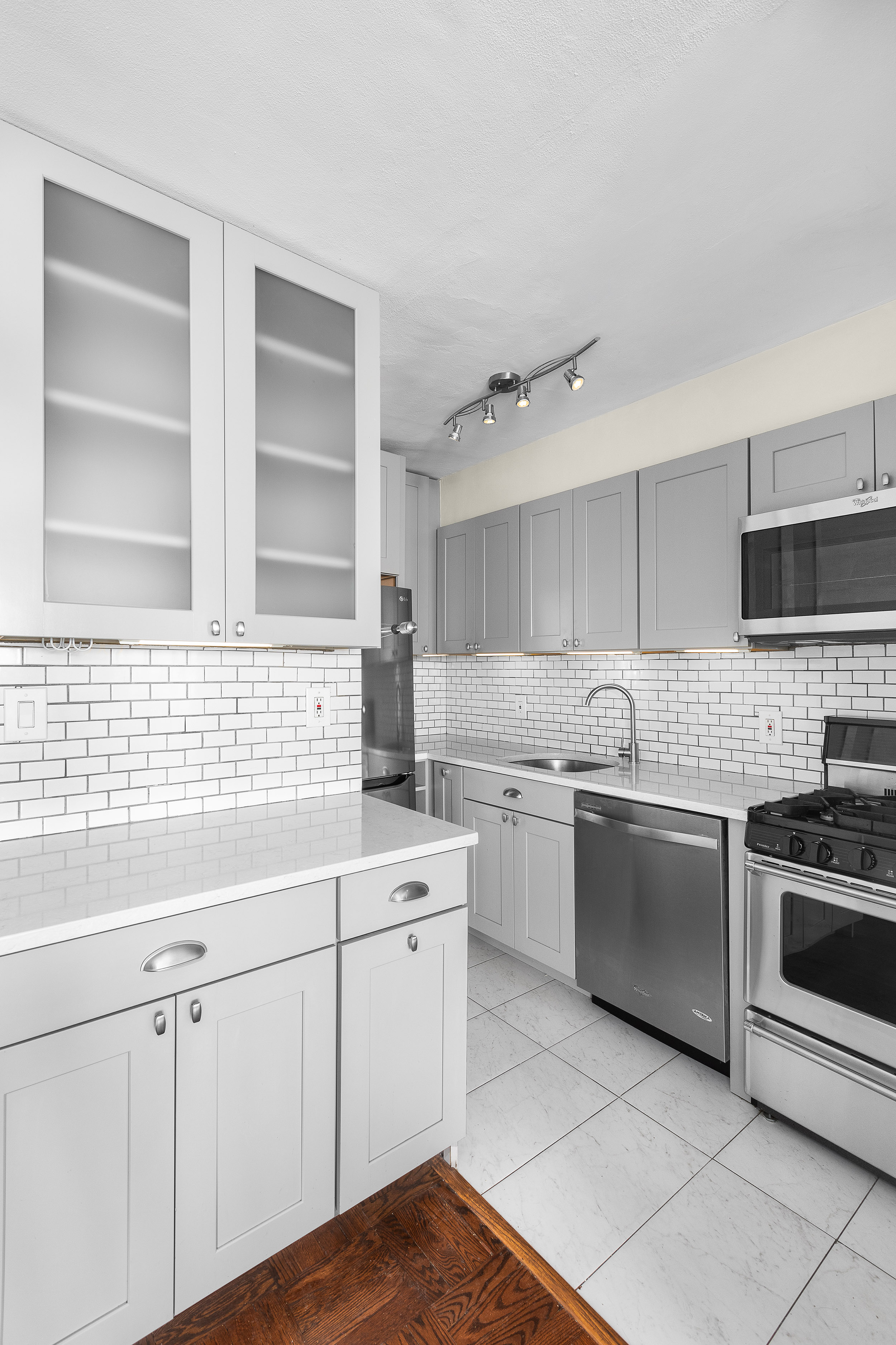 139 East 33rd Street, Unit 15G Manhattan, NY 10016 - Photo 7 of 11 a kitchen with a sink stove and cabinets