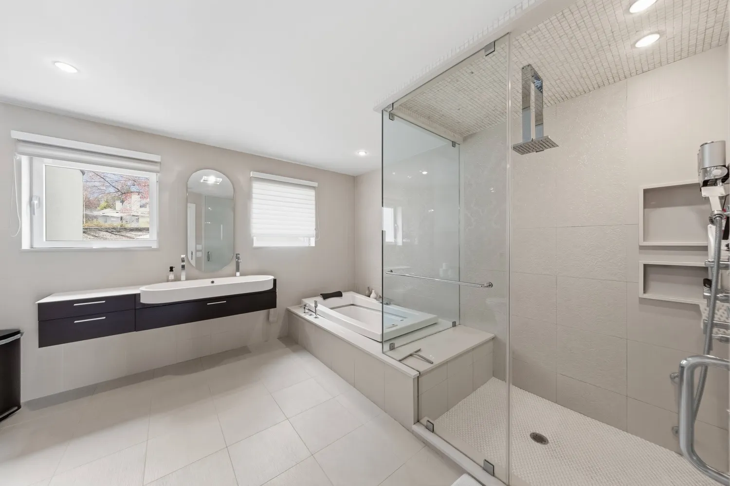 a spacious bathroom with a double vanity sink a mirror and a bathtub