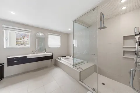 a spacious bathroom with a double vanity sink a mirror and a bathtub