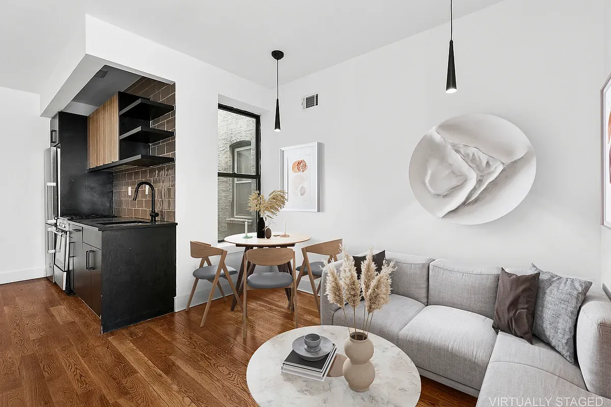 a living room with furniture a flat screen tv and kitchen view