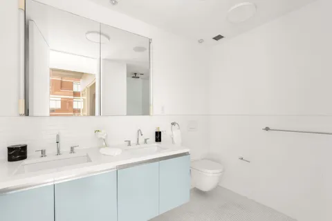 a bathroom with a toilet a sink a mirror and vanity