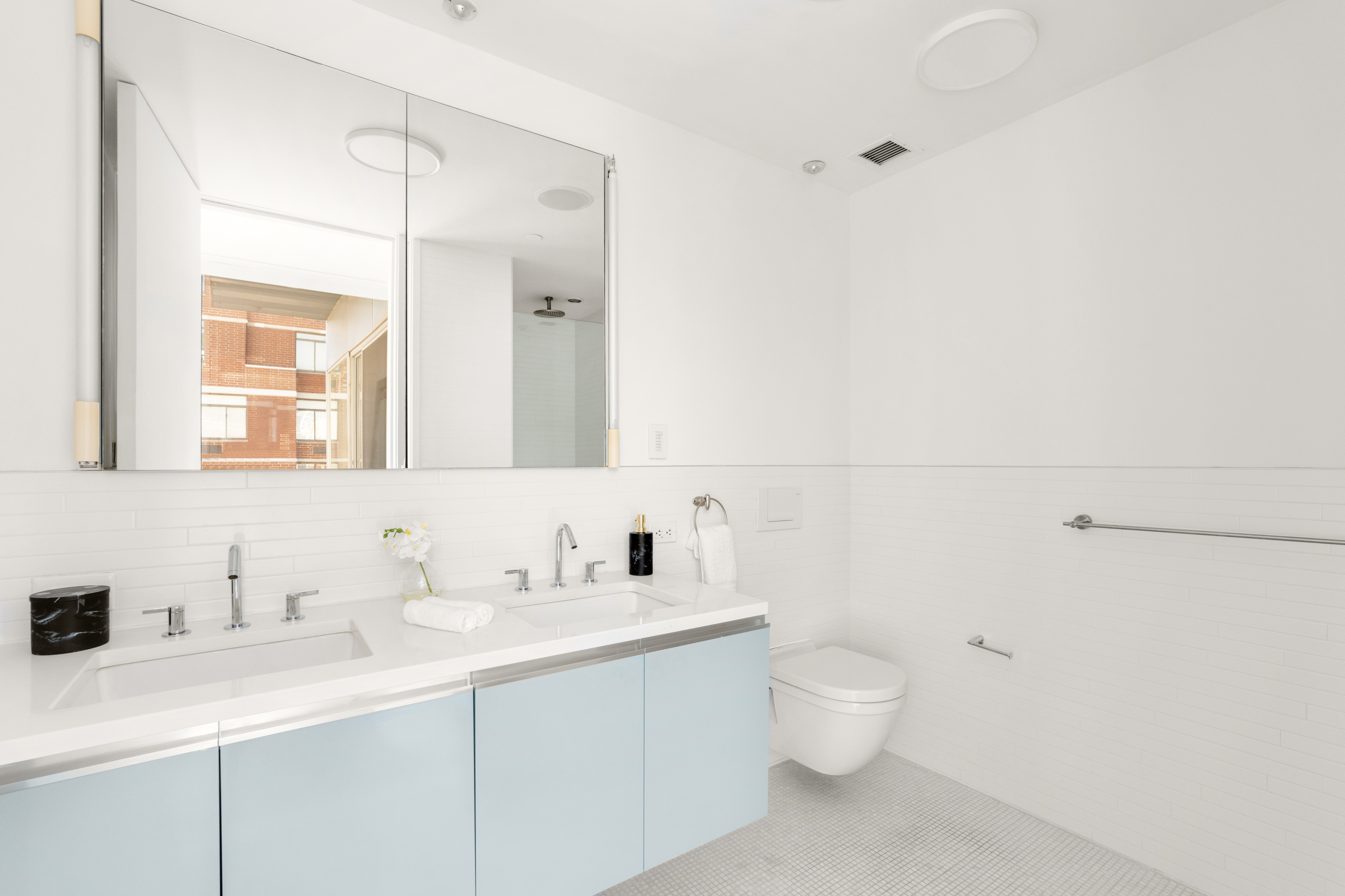 245 West 19th Street, Unit PH4 Manhattan, NY 10011 - Photo 6 of 10 a bathroom with a toilet a sink a mirror and vanity