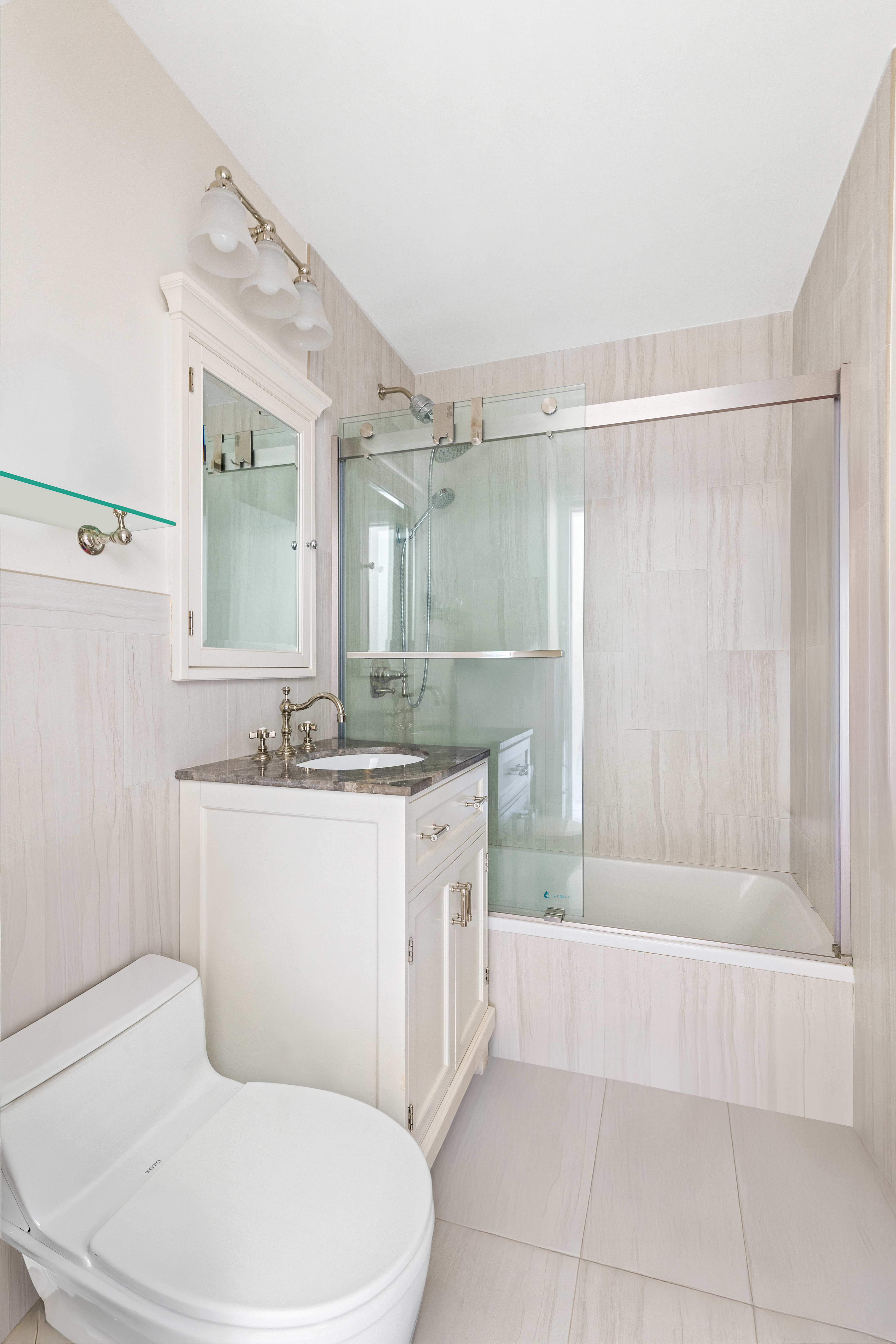551 Main Street, Unit 208 Manhattan, NY 10044 - Photo 13 of 36 a bathroom with a granite countertop bathtub sink vanity mirror and toilet