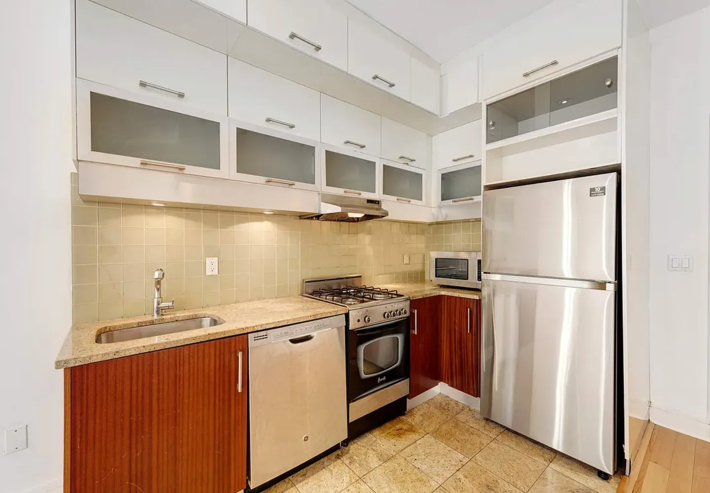 a kitchen with stainless steel appliances granite countertop a refrigerator a sink dishwasher a stove and a refrigerator