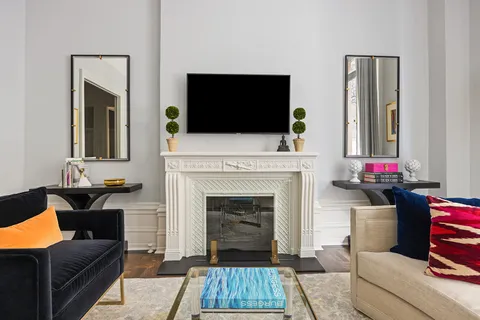 a living room with furniture a flat screen tv and a fireplace