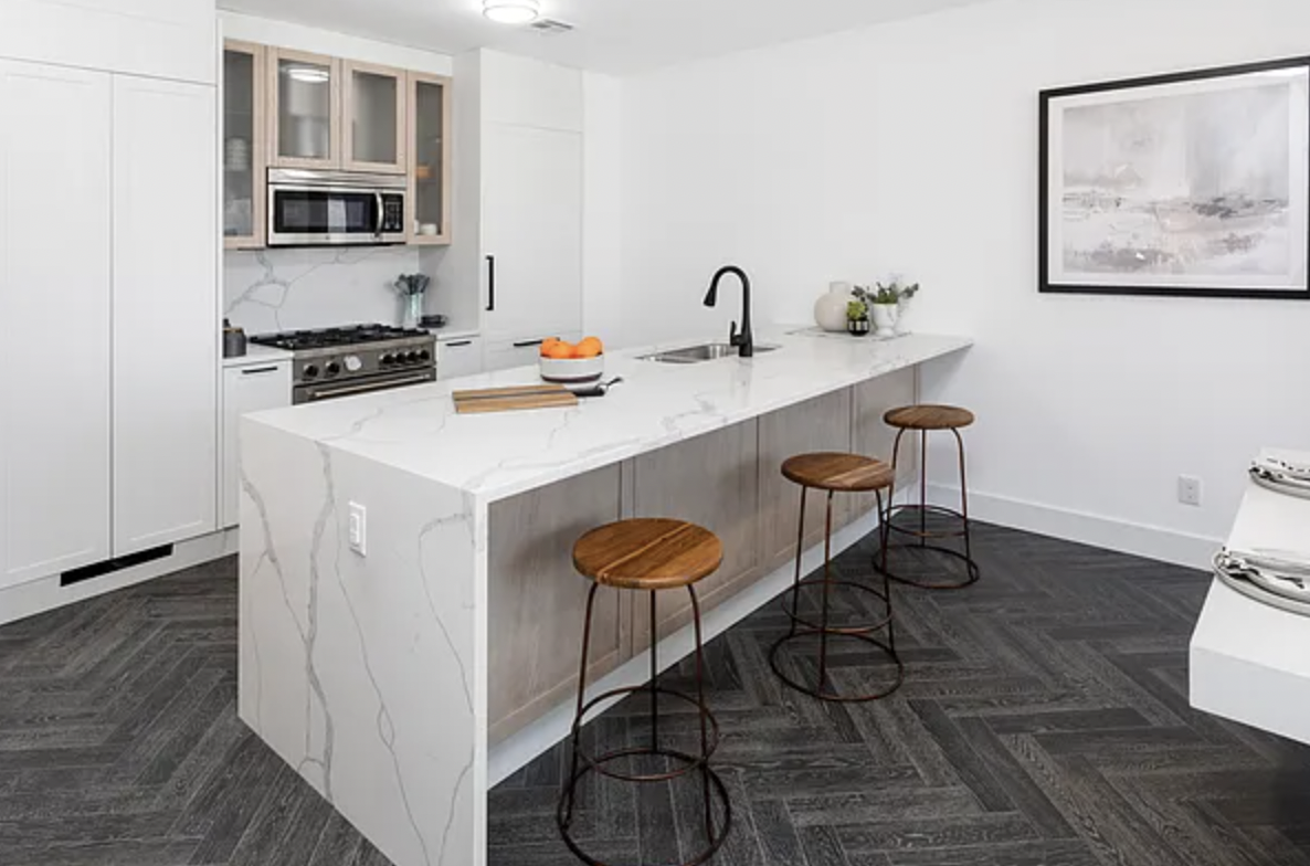a kitchen with a sink cabinets and wooden floor