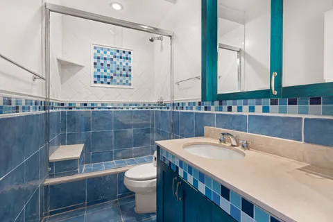 a bathroom with a sink a toilet and a mirror