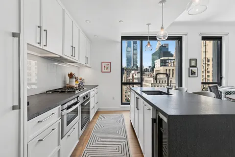 a kitchen with stainless steel appliances granite countertop a sink a stove and a wooden floors