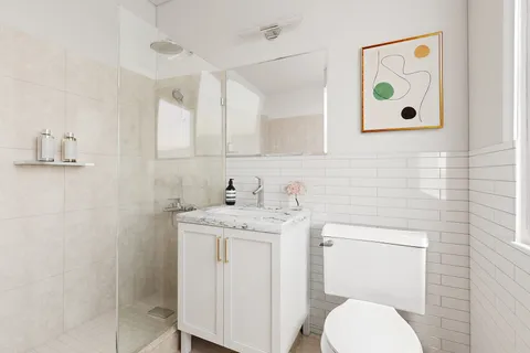 a bathroom with a granite countertop toilet sink and mirror