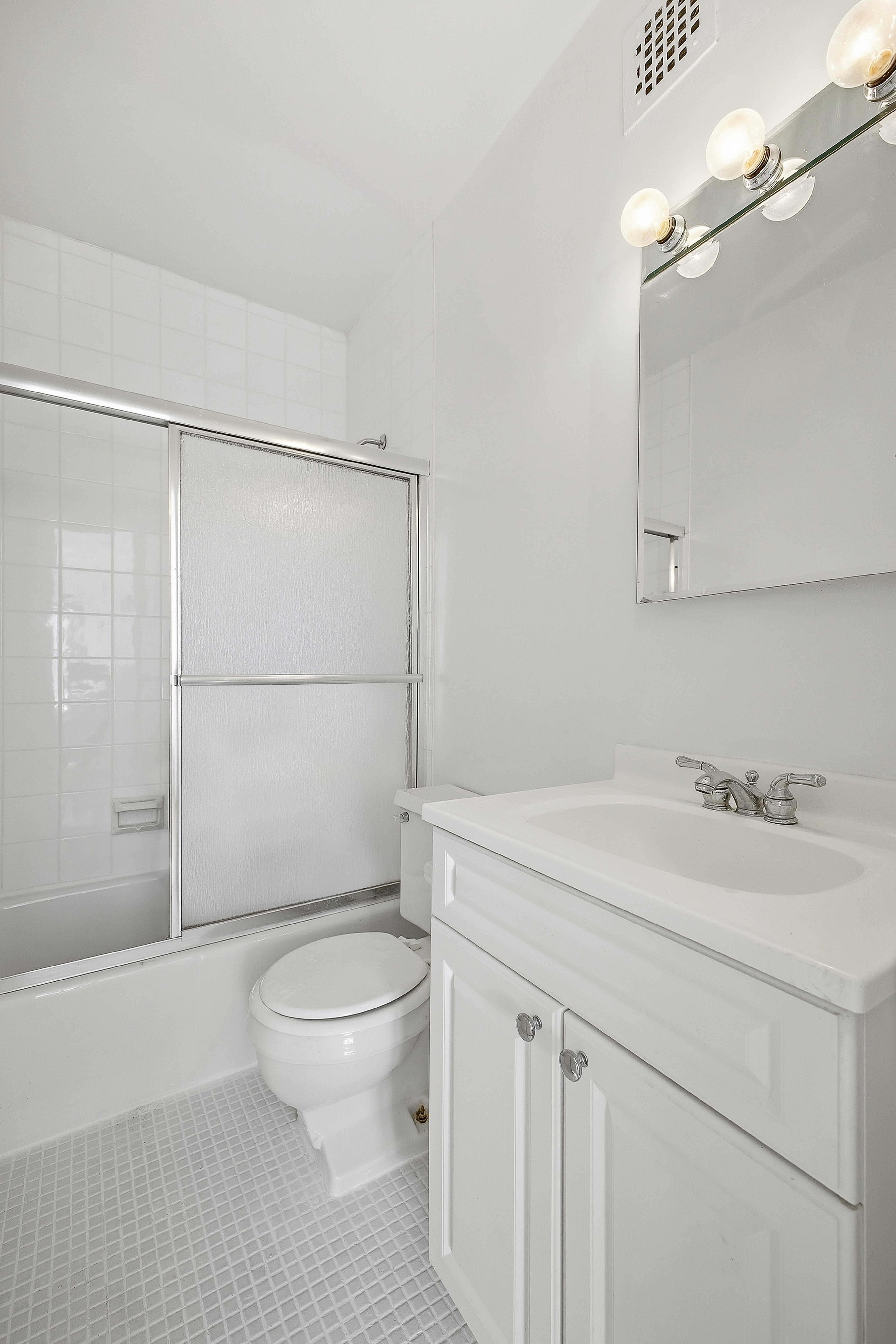 160 East 38th Street, Unit 26FG Manhattan, NY 10016 - Photo 12 of 23 a bathroom with a granite countertop sink toilet a mirror and shower