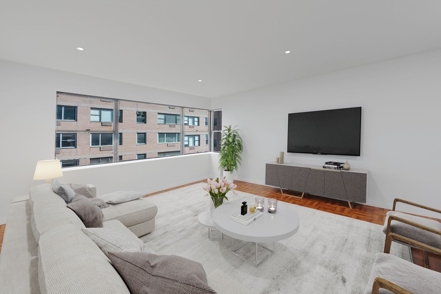 45 Sutton Place South, Unit 16B Manhattan, NY 10022 - Photo 5 of 19 a living room with furniture and a flat screen tv