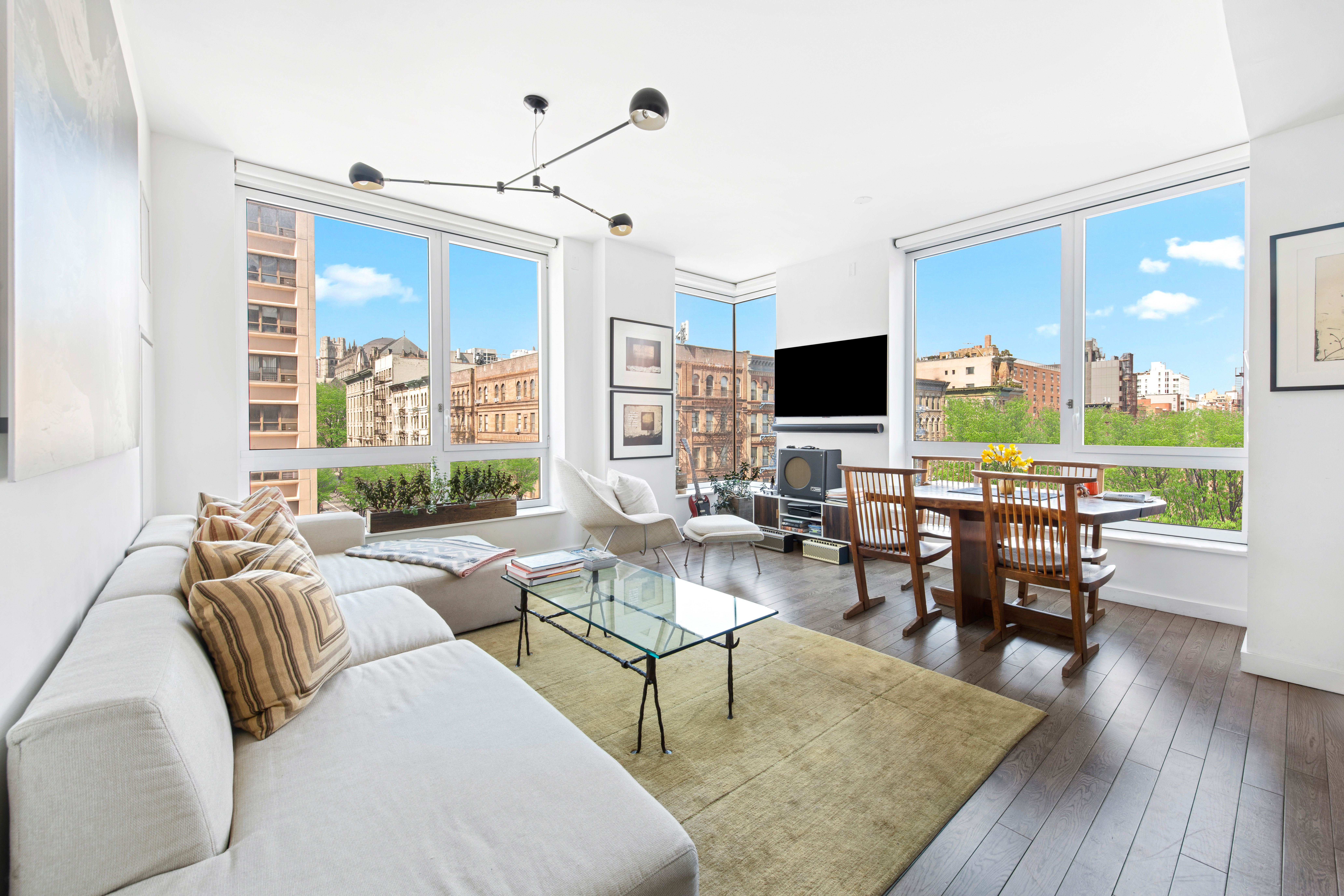 a living room with furniture flat screen tv and a large window