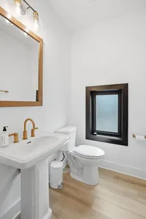 a bathroom with a toilet sink and mirror