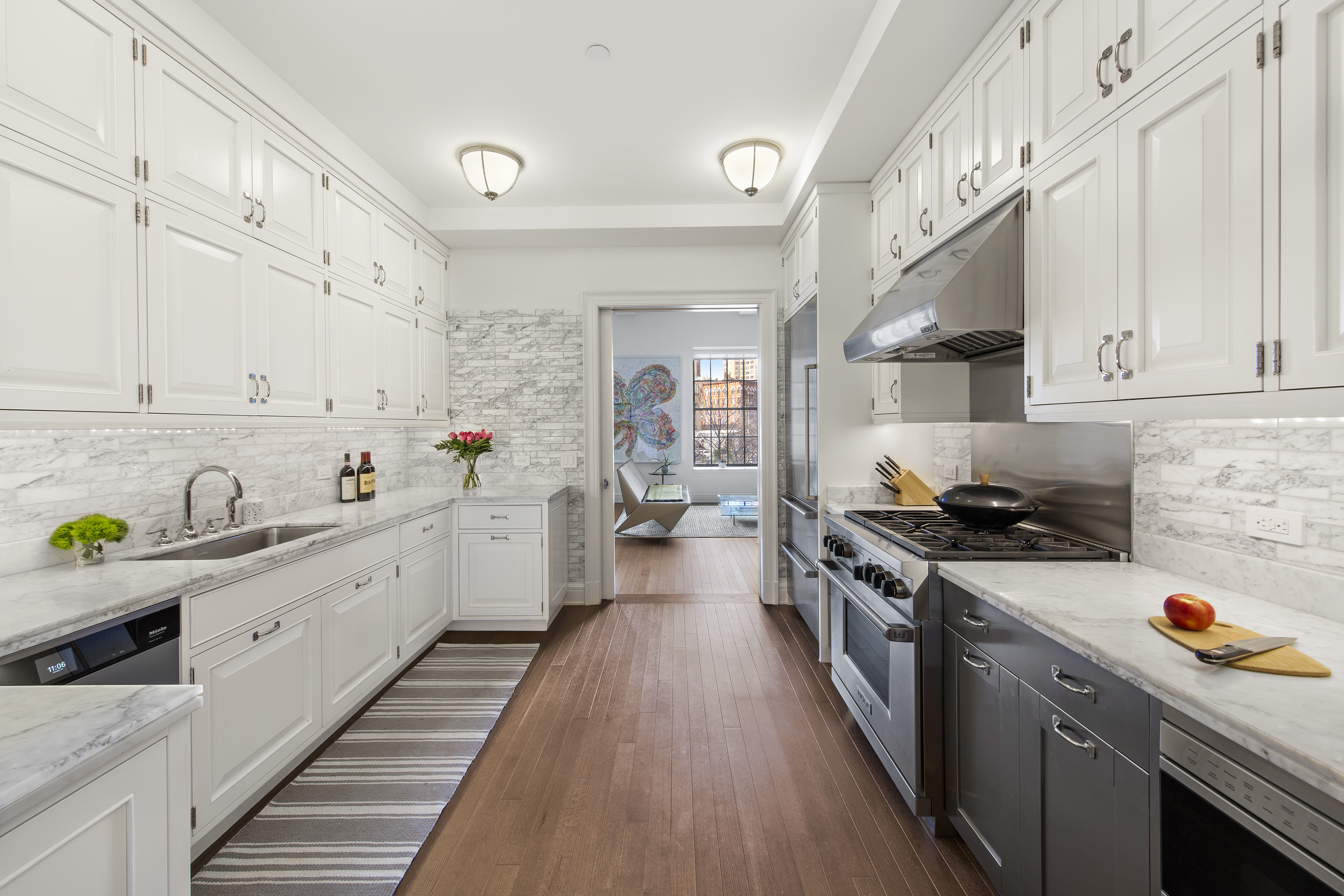 160 West 12th Street, Unit 28 Manhattan, NY 10011 - Photo 2 of 9 a kitchen with kitchen island granite countertop lots of counter top space a sink and stainless steel appliances