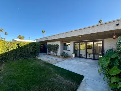 a view of a house with porch and garden