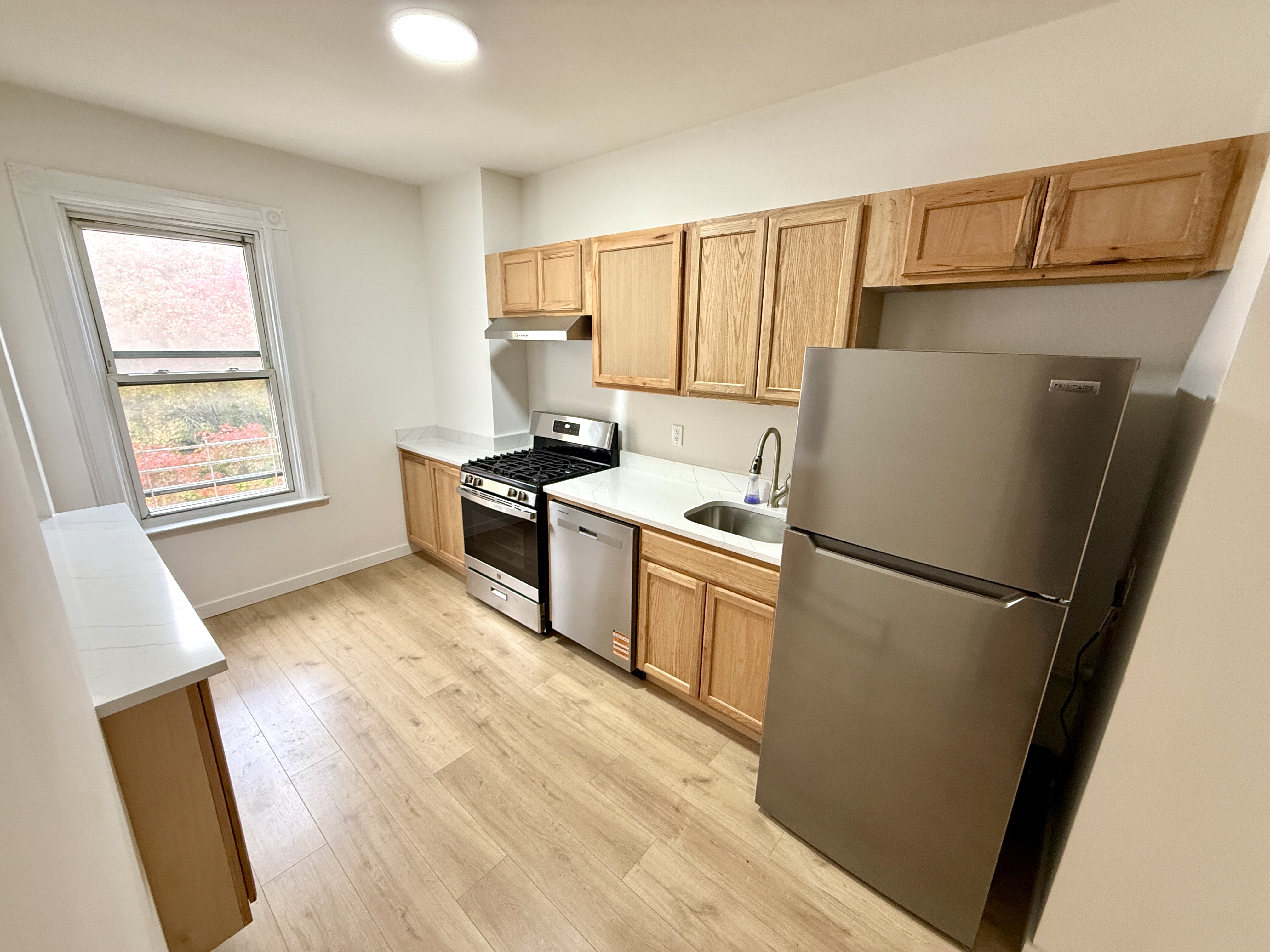 31 Seeley Street, Unit Undisclosed Brooklyn, NY 11218 - Photo 11 of 31 a kitchen with a refrigerator a stove top oven a sink and dishwasher with wooden floor