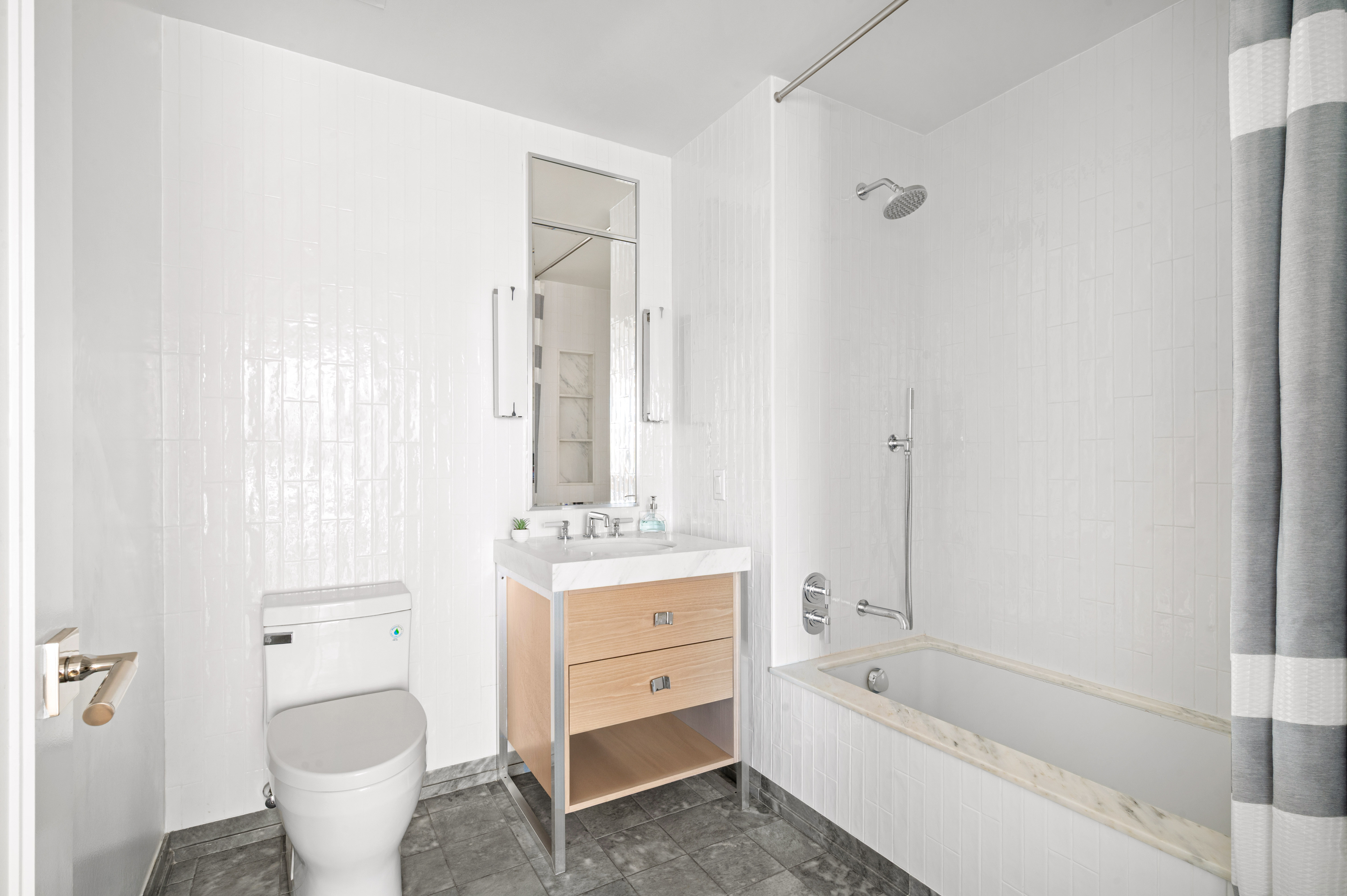 368 3rd Avenue, Unit 11AA Manhattan, NY 10016 - Photo 9 of 18 a bathroom with a granite countertop toilet a sink and a bathtub